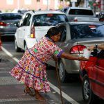 A member from the indigenous Warao people from the Orinoco Delta in eastern Venezuela, asks for money from a driver in Manaus